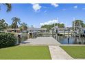 Wide-angle view of a backyard dock with boat lifts and neighborhood canal on a sunny day at 1361 46Th Ne Ave, St Petersburg, FL 33703
