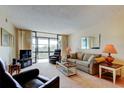 Bright living room with comfortable seating, neutral colors, and sliding glass doors to balcony at 14130 Rosemary Ln # 3312, Largo, FL 33774