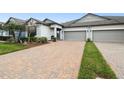 Attractive townhome with a brick driveway, lush lawn, and two-car garage at 16822 Balance Cv, Land O Lakes, FL 34638