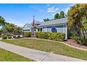 Charming home exterior with manicured lawn, mature landscaping, and attached garage at 1700 Hunter Ln, Tarpon Springs, FL 34689