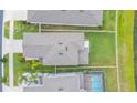 Birds-eye view of the backyard with green grass and neighborhood pool in the background at 20925 Monza Loop, Land O Lakes, FL 34638