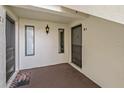View of the front entry with carpeted foyer, decorative light and glass accent windows at 2699 Pine Ridge E Way # H1, Palm Harbor, FL 34684
