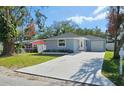 Well-maintained single-story home with a manicured lawn, a private driveway, and an attached garage at 2712 60Th N Ave, St Petersburg, FL 33714