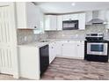 Modern kitchen featuring white cabinets, stainless steel appliances, and granite countertops at 2712 60Th N Ave, St Petersburg, FL 33714