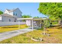 Large backyard with a covered parking, lush lawn, privacy fence, and mature trees at 2827 1St Ne St, St Petersburg, FL 33704