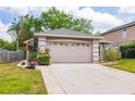 Beige single-Gathering home with a two-car garage, well-kept lawn, and bright flower arrangements at 3574 Ridge Blvd, Palm Harbor, FL 34684