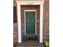 Close-up of a green front door with white trim and brick surround, creating a welcoming entrance at 4624 W North B St, Tampa, FL 33609