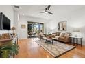 Inviting living room featuring hardwood floors, ceiling fan, neutral paint, and a sliding door to the lanai at 8078 Pine Crest St, Seminole, FL 33777