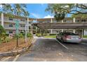 Condo parking area featuring covered parking and a well-maintained landscape with clear signage at 870 Virginia St # 109, Dunedin, FL 34698