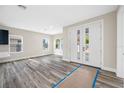 Bright, airy living room with gray wood floors, neutral walls, and double front doors, creating a welcoming, modern space at 1030 11Th S Ave, St Petersburg, FL 33705