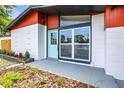 Home featuring a vibrant blue door and modern design at 10909 N Lantana Ave, Tampa, FL 33612