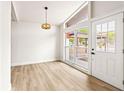 Bright living room with laminate flooring, a pendant light and a large window at 10909 N Lantana Ave, Tampa, FL 33612