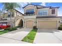 Townhouse exterior with manicured lawn, neutral paint, covered entrance and two-car garage at 11521 Crowned Sparrow Ln, Tampa, FL 33626