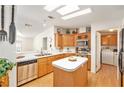 Bright kitchen with a skylight, stainless steel appliances, wood cabinets, and a center island at 12501 Ulmerton Rd # 133, Largo, FL 33774