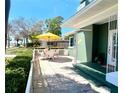 Serene patio with ample seating and a yellow umbrella offering shade, ideal for enjoying the outdoors at 126 Orangewood Dr, Dunedin, FL 34698