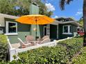 A charming outdoor seating area with a glass table and umbrella, perfect for relaxing or entertaining at 126 Orangewood Dr, Dunedin, FL 34698