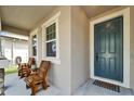 Inviting front porch with chairs and a decorative welcome mat by the front door at 13113 Rain Lily Dr, Riverview, FL 33579