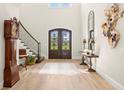 Inviting foyer featuring a staircase, stylish decor, and elegant double doors with decorative ironwork at 16119 Carencia Ln, Odessa, FL 33556