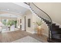 Elegant foyer featuring a curved staircase, wood floors, and views into the dining room with lots of natural light at 16119 Carencia Ln, Odessa, FL 33556