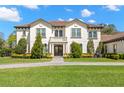 Elegant two-story home featuring manicured landscaping and a symmetrical facade with stone accents at 16119 Carencia Ln, Odessa, FL 33556