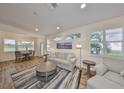 Open-concept living room featuring hardwood floors, large windows, and a comfortable seating area at 1916 Inverness Greens Dr, Sun City Center, FL 33573