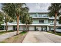 Inviting two-story condo with driveways, garages, and mature palm trees at 2515 Bay Blvd # A, Indian Rocks Beach, FL 33785