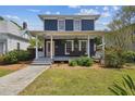 Charming two-story home featuring a covered front porch with seating and manicured landscaping at 2807 N Morgan St, Tampa, FL 33602