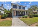 Charming two-story home featuring a covered front porch with seating and manicured landscaping at 2807 N Morgan St, Tampa, FL 33602