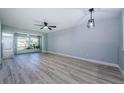 Open-concept living room featuring new floors and light filled sunroom, perfect for relaxation and entertaining at 3143 Mission Grove Dr, Palm Harbor, FL 34684