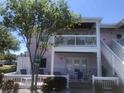 Condo exterior featuring a private patio, balcony, white railings and a view of the landscaped yard at 4794 Cobia Se Dr # D, St Petersburg, FL 33705