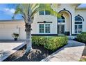 Home exterior featuring an arched entryway, well-maintained landscaping, and a paver walkway leading to the front door at 706 Bunker View Dr, Apollo Beach, FL 33572