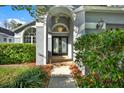 Elegant front entrance with double doors, brick walkway, and lush landscaping at 11831 Lancashire Dr, Tampa, FL 33626