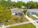 Aerial view showcases a well-maintained single-story home, driveway and mature landscaping at 1254 8Th Ne Ave, Largo, FL 33770