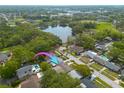 Aerial shot of neighborhood, showing house, pool, streets, and community lake nearby at 1254 8Th Ne Ave, Largo, FL 33770