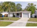 Inviting front exterior of a single-story home with a red door and freshly painted exterior at 1254 8Th Ne Ave, Largo, FL 33770
