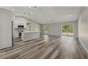 Spacious living room featuring wood flooring, a kitchen island, recessed lighting, and a sliding glass door at 15409 Coot Rd, Weeki Wachee, FL 34614