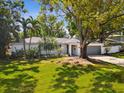Charming single-story home featuring a brick exterior, mature trees and a well-manicured lawn at 1666 N Dakota Ne Ave, St Petersburg, FL 33703