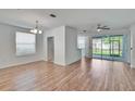 Bright living room with wood floors, ceiling fan, and sliding door access to a screened-in patio at 2119 Kings Palace Dr, Riverview, FL 33578