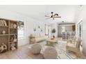 Comfortable living room with tile floors, a ceiling fan, and an open view of the kitchen and backyard at 2449 Running Oak Ct, Spring Hill, FL 34608