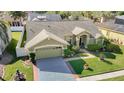 Aerial shot of a well-maintained home with a manicured lawn, mature trees, and an attached two-car garage at 28402 Openfield Loop, Wesley Chapel, FL 33543
