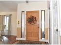 Light-filled foyer featuring a beautiful front door with sidelights, hardwood floors and stylish rug at 3189 Roxmere Dr, Palm Harbor, FL 34685