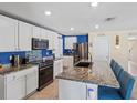 Modern kitchen featuring granite countertops, stainless steel appliances, and an island with bar seating at 36541 Night Strawberry Ct, Dade City, FL 33525