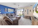 Comfortable living room with plush seating, neutral carpet, and sliding glass doors to the backyard at 36541 Night Strawberry Ct, Dade City, FL 33525