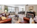 Cozy living room featuring hardwood floors, a fireplace, leather furniture, and plantation shutters at 4720 Locust Ne St # 206, St Petersburg, FL 33703