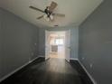 An empty room shows an open doorway into the kitchen and tan ceiling fan at 4731 Portobello Cir, Valrico, FL 33596