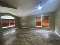 A spacious living room features two windows with wood blinds and sleek, light laminate flooring at 4731 Portobello Cir, Valrico, FL 33596