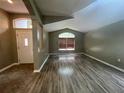 A bright living room featuring light gray walls, a large window, and wood laminate flooring at 4731 Portobello Cir, Valrico, FL 33596