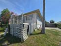 Exterior view featuring a raised porch/deck and a carport in the background at 613 Chestnut St, Oldsmar, FL 34677