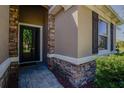 Front door with stone accents and detailed trim, set amongst manicured greenery at 6312 Lantern View Pl, Apollo Beach, FL 33572