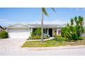 Beautiful single-story home showcasing lush landscaping, a welcoming entrance, and an attached two-car garage at 7321 San Moritz Dr, Port Richey, FL 34668